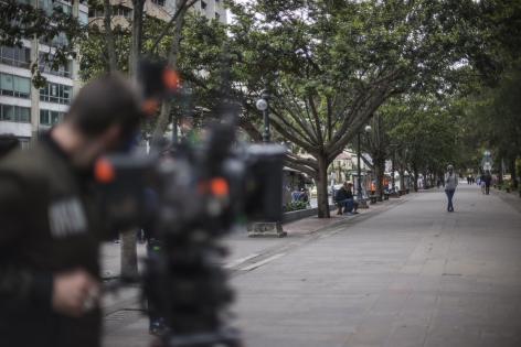 Una cámara de cine grabando en una calle con árboles en la ciudad